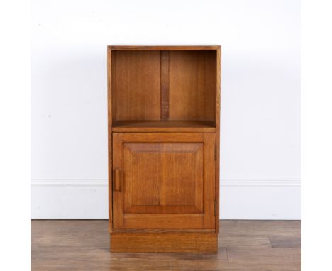 Attributed to Heals oak, small cupboard or bedside table, with open shelf above a fielded panel door, standing on a plinth ba