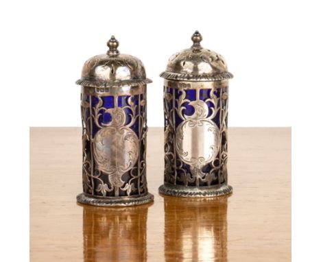Pair of Edward VII silver pepperetteswith pierced decoration of birds and foliage, with blue glass liners, bearing marks for 