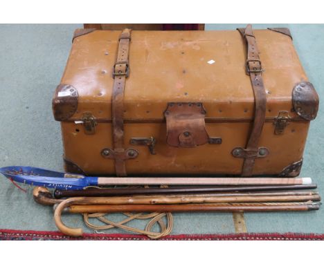 A lot comprising 19th century leather travel trunk with leather capped corners, four assorted walking sticks, carpet beater, 