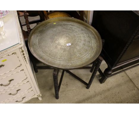 A Benares brass tray on carved folding stand 