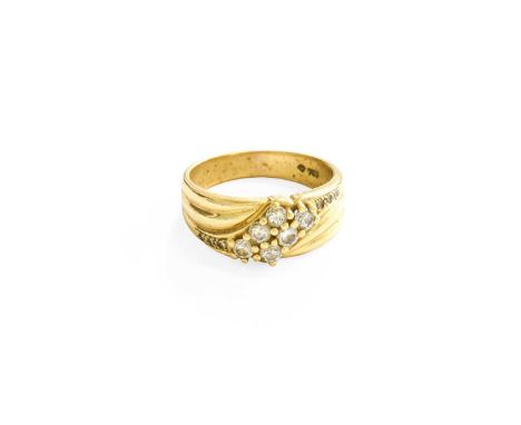 A Diamond Crossover Ring, the round brilliant cut diamonds, in yellow claw settings, to a broad tapered shoulder plain polish
