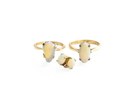 An Opal Ring, the oval opal cabochon in a yellow claw setting, to a plain polished shank, finger size P; An Opal Ring, the pe