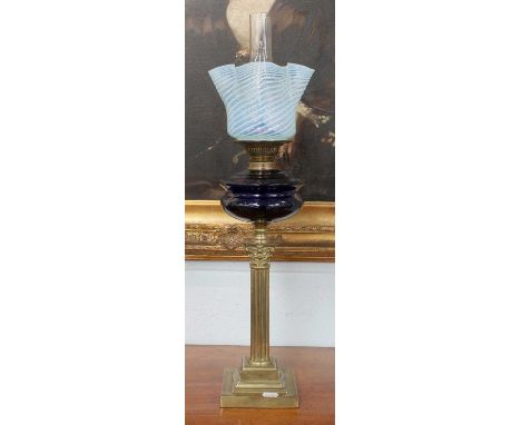 A Victorian Oil Lamp, with brass column corinthian base, blue glass resovoir and light blue ryhthen shade, 75cm high