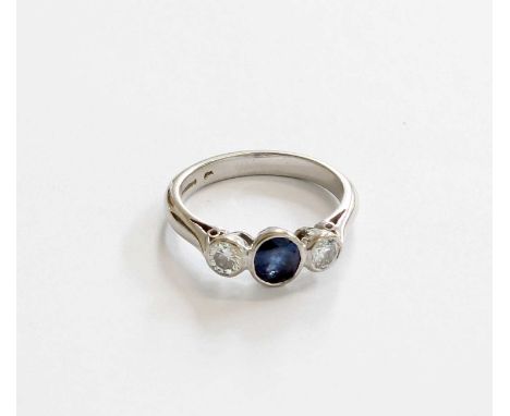 An 18 Carat White Gold Sapphire and Diamond Three Stone Ring, the oval cut sapphire flanked by round brilliant cut diamonds i