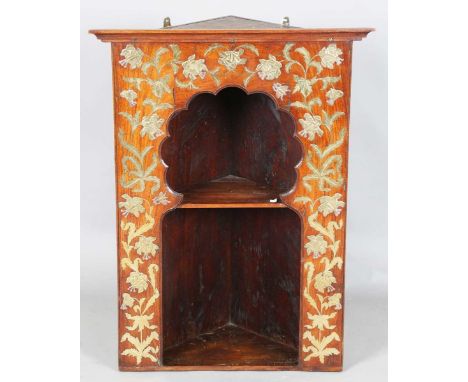 A late 19th century Aesthetic Movement Moorish walnut corner display shelf, the arched niche fitted with two shelves, the sur