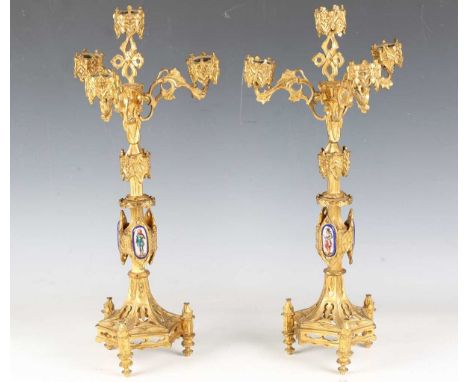 A pair of late 19th century French Gothic Revival cast ormolu four-light candelabra, each stem applied with three enamelled p