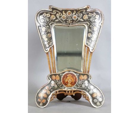 A French Art Nouveau silvered and painted dressing table mirror of shaped outline, decorated with trailing leaves, flowerhead