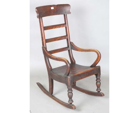 A Victorian provincial mahogany rocking armchair with ladder back and solid seat, height 104cm, width 52cm. Provenance: from 