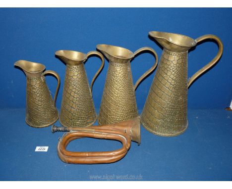 A bugle and graduated set of four brass measuring jugs. 
