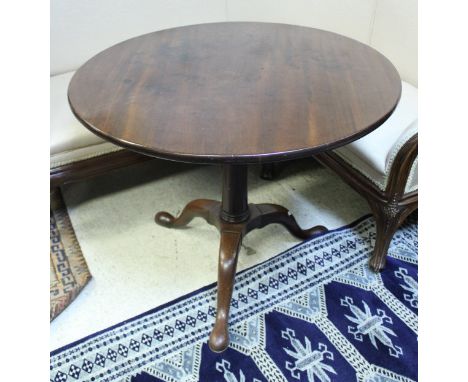 A 19th Century mahogany tea table, the circular top on a turned pedestal to cabriole tripod base