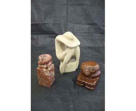 A Chinese carved soap stone seal with snake finial, a carved stone figure of a seated man and a carved stone figure of a seat