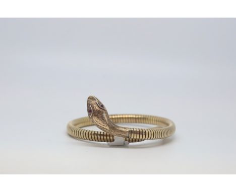 9ct yellow gold snake bangle, carved snake head set with garnet eyes, on a flexible coiled bangle, with a steel spring