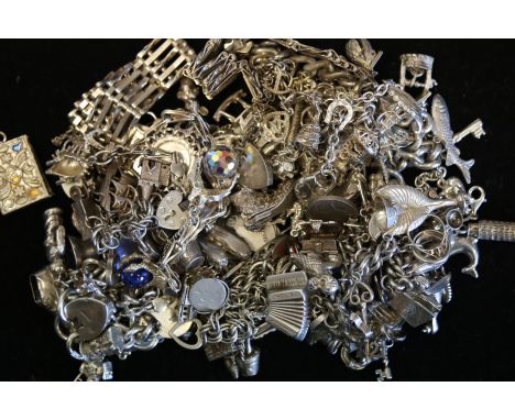 A quantity of mostly vintage silver charm bracelets and charms, weighing approximately 594g gross