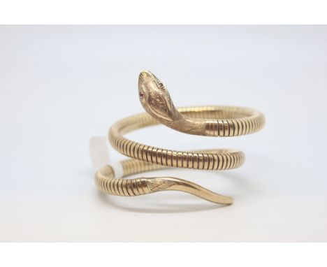 9ct yellow gold snake bangle, carved snake head set with garnet eyes, on a flexible coiled bangle, with a steel spring