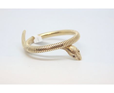 9ct yellow gold snake bangle, carved snake head set with garnet eyes, on a flexible coiled bangle, with a steel spring