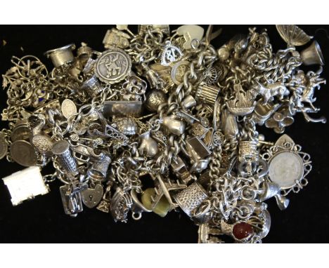 A quantity of mostly vintage silver charm bracelets and charms, weighing approximately 538g gross
