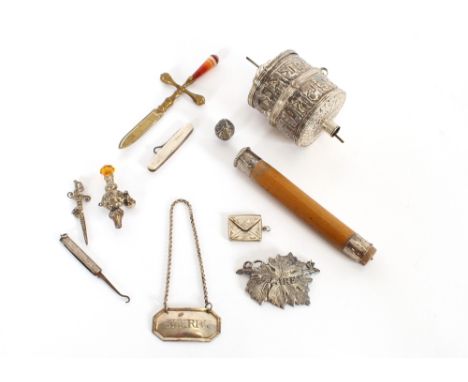 An Eastern white metal prayer wheel, AF; a silvered baby's rattle, AF; various other objects to include an agate handled pape