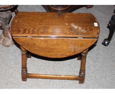 A good quality reproduction oak gate leg coffee table, the rounded drop leaves raised on turned supports united by stretchers