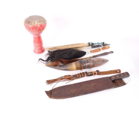 A machette in leather scabbard; a horn vessel; various fly whisks; an ethnic drum etc.