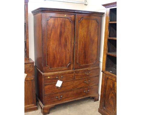 A George III mahogany linen press, the upper section fitted four sliding trays, two short and two long drawers below, raised 