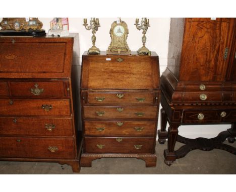 A Georgian mahogany bureau, of small proportions, the hinged fall opening to reveal an interior arrangement of drawers and pi