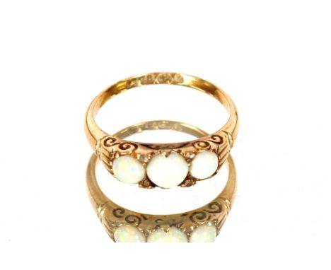 An 18 carat gold opal and chip diamond set ring; an 18 carat gold wedding band; a yellow metal and white stone set eternity r