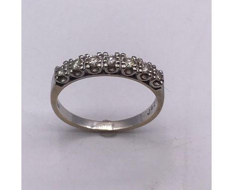 A Round Brilliant cut diamond seven stone half eternity ring, white claw set U0shape settings to a flat section shank with st