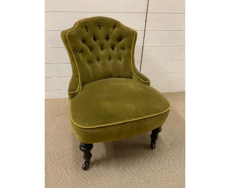 An olive button back bedroom chair on turned legs and castors (H70cm W56cm)