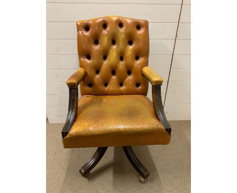 A leather button back office chair on castors 