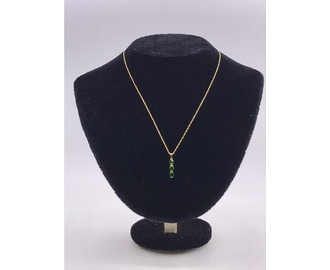 A 9ct gold and emerald three stone pendant with gold neck chain on a bolt ring clasp detailed 375.(Total Weight 1.9g)