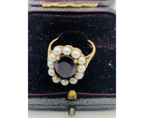 A 9ct gold garnet and seed pearl ring.