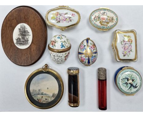 Six enamelled trinket boxes by Limoges and Halcyon Days, a Victorian red glass cylindrical scent bottle with white metal lid,