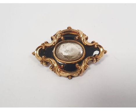Victorian gold and black enamel memorial brooch, lozenge-shaped and scroll embossed, centred by hair twist, inscription verso