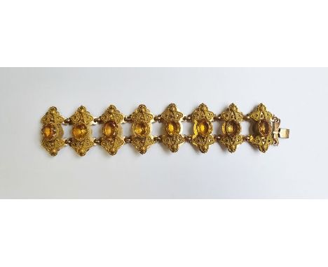 Gold-coloured metal ornate citrine set bracelet, each shaped panel set with oval citrine-coloured stone surrounded by pierced