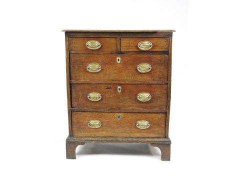An oak chest of drawers, 18th century, with alterations, the rectangular bevelled planked top above two short and three longs