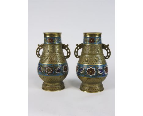 A pair of Chinese brass and champleve two handled vases, in archaic style, each with bands of flowers and characters against 