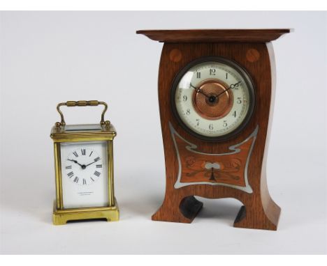 An inlaid oak cased Art Nouveau mantel timepiece circa 1900, of organic outline with exaggerated cornice, inlaid with white m