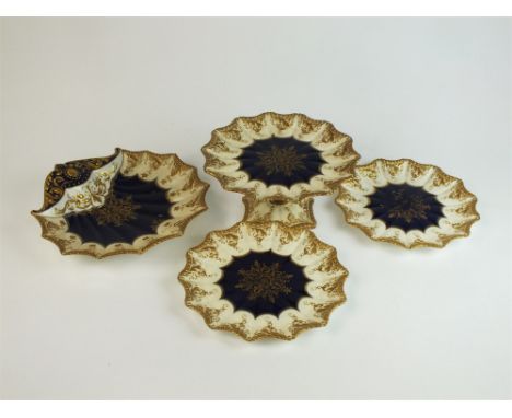 An Aynsley partial dessert service, circa 1891-1910, decorated with cobalt centres between an overall blush ivory ground and 
