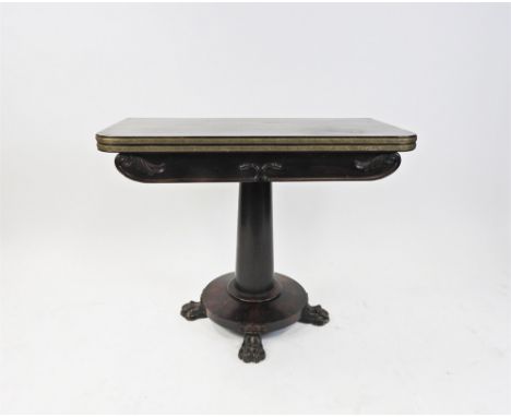 A William IV rosewood card table the gilt metal mounted fold-over top, raised on an oak and acorn leaf carved frieze and gun 