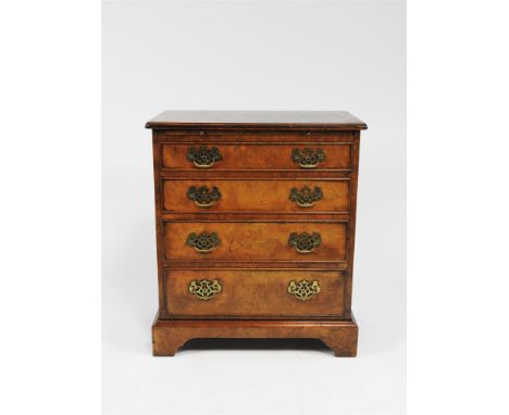 A reproduction figured walnut bachelor's chest, in George III style, the rectangular boxwood strung top above a brushing slid