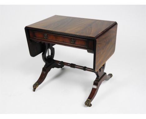 A reproduction mahogany veneered and crossbanded sofa table of small proportions with shallow frieze drawer and raised on lyr