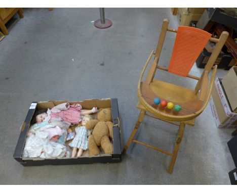 A collection of vintage dolls and a high chair 