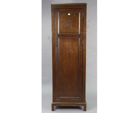 A mid-20th century oak tall hall cupboard enclosed by a panel door, &amp; on a shaped plinth base, 23¼” wide x 73¼” x 15½” de