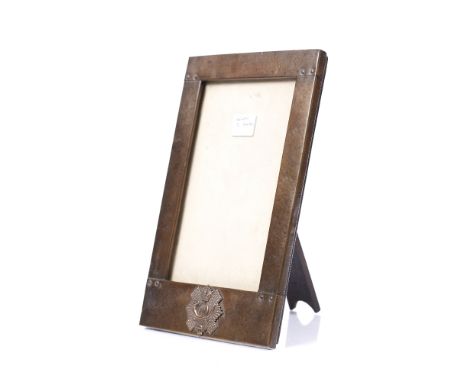 AN ARTS &amp; CRAFTS BEATEN COPPER RECTANGULAR PHOTOGRAPH FRAME bearing the badge for the 74th Highland Light Infantry commem