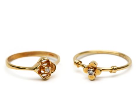 Twee 14 kt. gouden fijne ringen, met bloemvormige kop, beide bezet met een kleine diamant van ieder ca. 0.02 ct. [2] bruto 3,