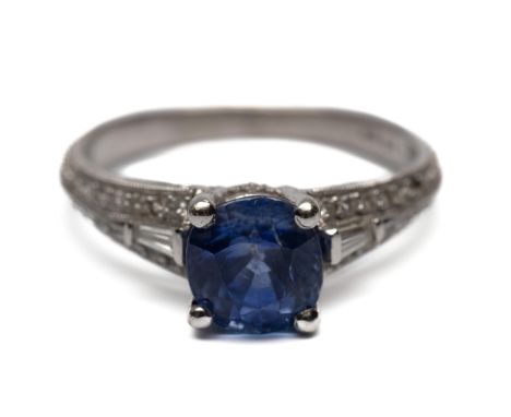 Platina ring met een blauwe saffier, met een diameter van ca. 7 mm. De schouders bezet met tapered en briljant geslepen diama