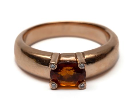 14 kt. Rosé gouden ring met een oranje granaat, van 8 x 6 mm, de pootjes elk gezet met een kleine briljant geslepen diamant [