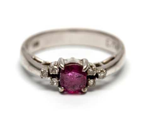 Beneden wettelijk gehalte witgouden ring, bezet met een robijn, met aan weerszijden drie kleine achtkant geslepen diamanten [
