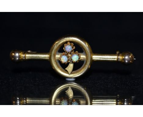 An Edwardian opal bar brooch, central cluster of three round opal cabochons, mounted upon a leaf setting, rounded frame, tubu