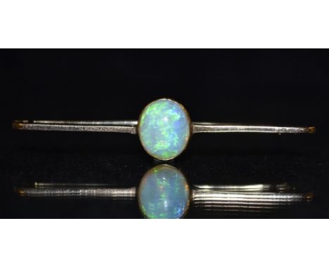 An opal bar brooch, central oval opal cabochon, flashing green, blue and red colour play, yellow metal bar and mount, unmarke